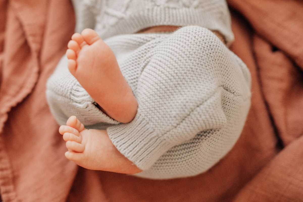 Cozy newborn baby photos of baby feet wrapped in soft blanket.
