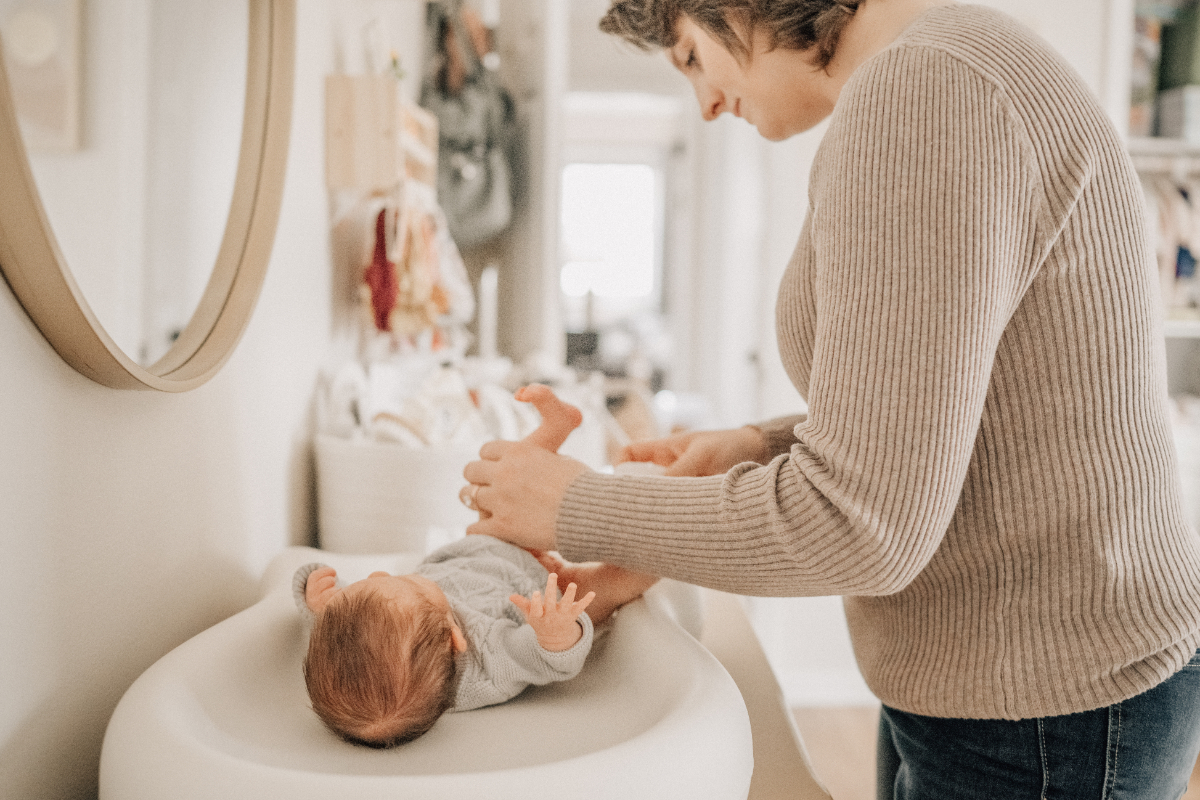 Lifestyle newborn baby photos of parent changing baby in nursery.