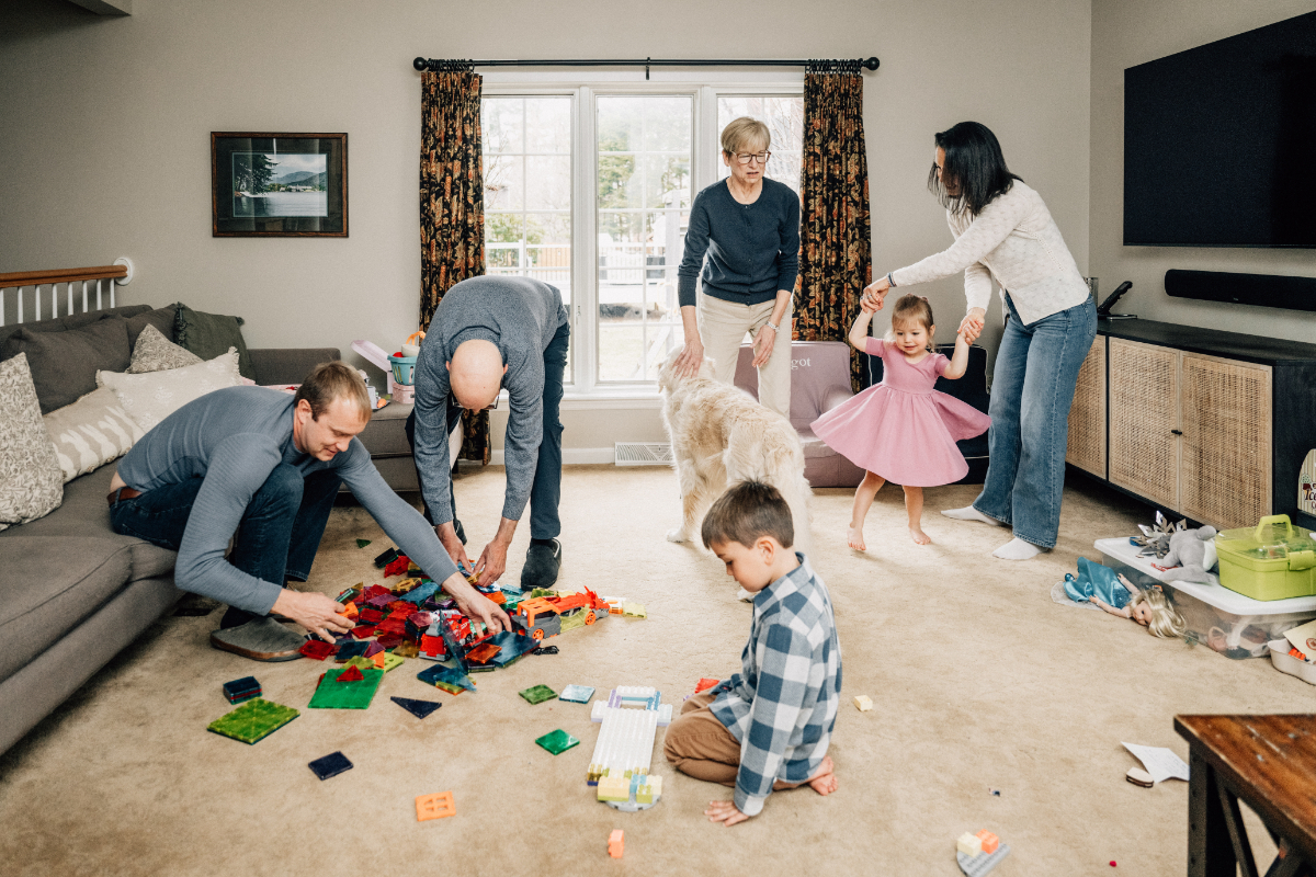 Young girl standing with large dog in living room, playful and gentle family interaction