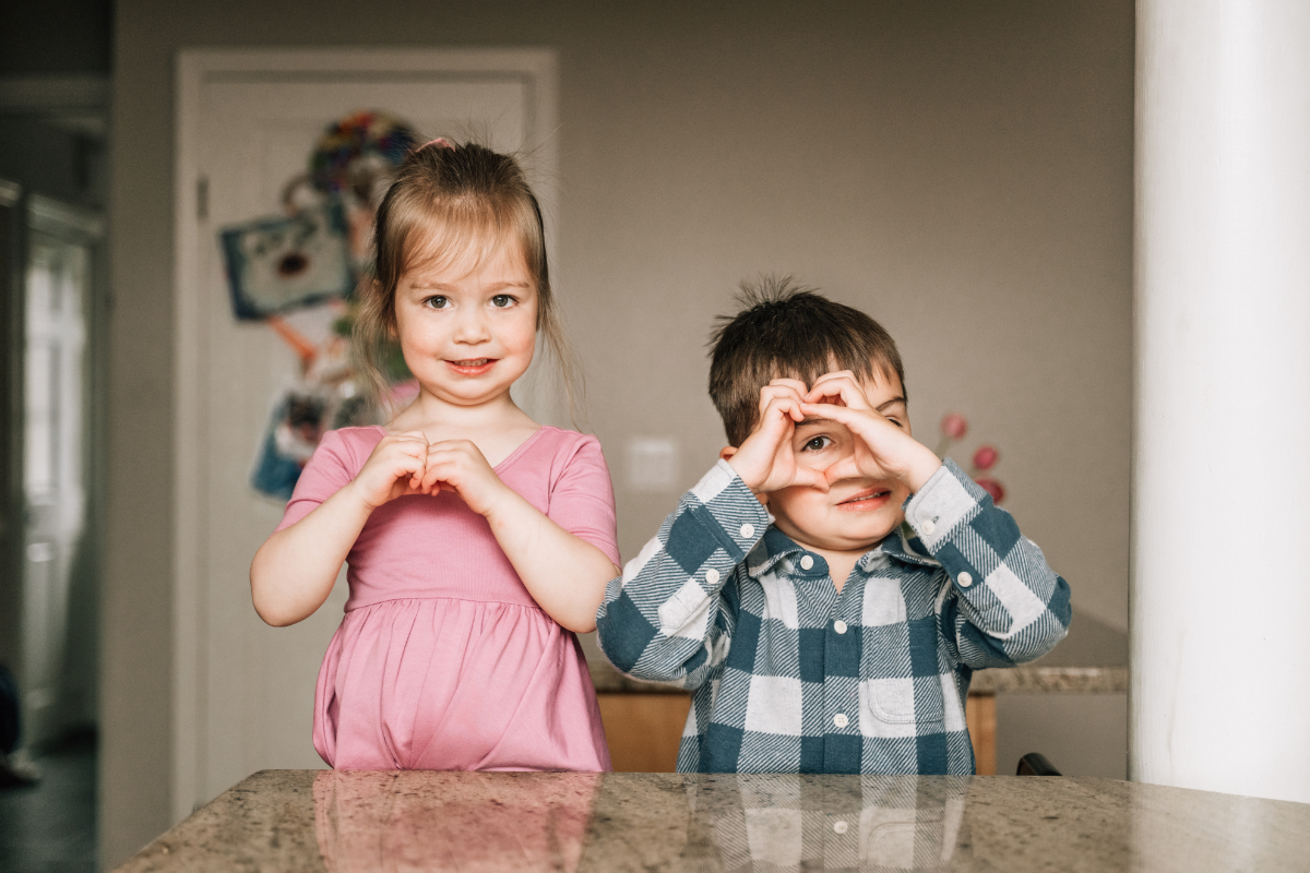 Children wrestling and laughing on floor while grandparents watch, playful and connected family scene