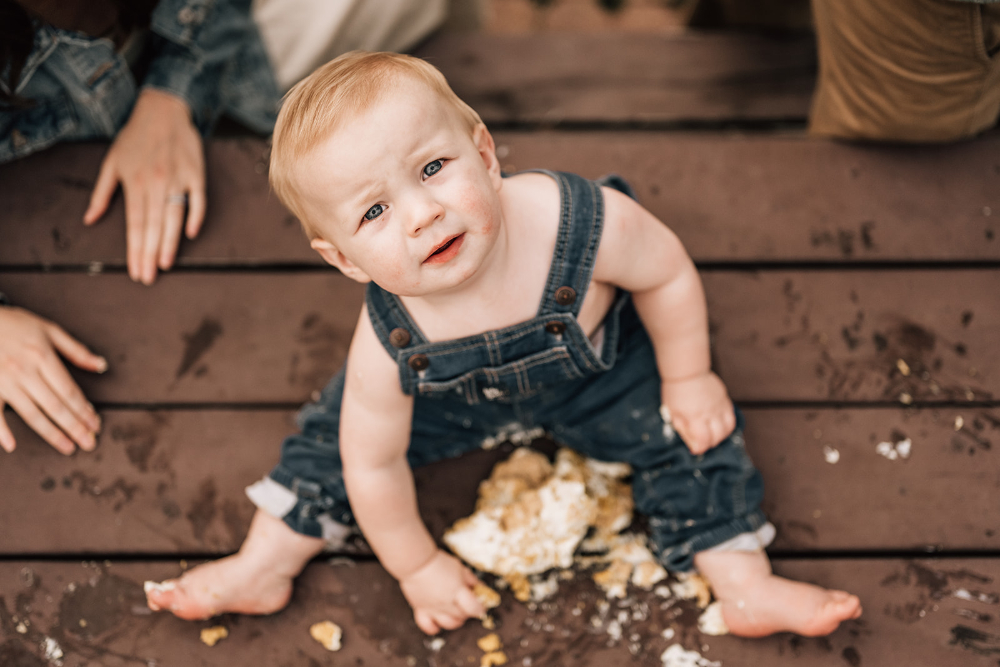 Close-up portrait of a curious one-year-old looking up during an outdoor family photography session.