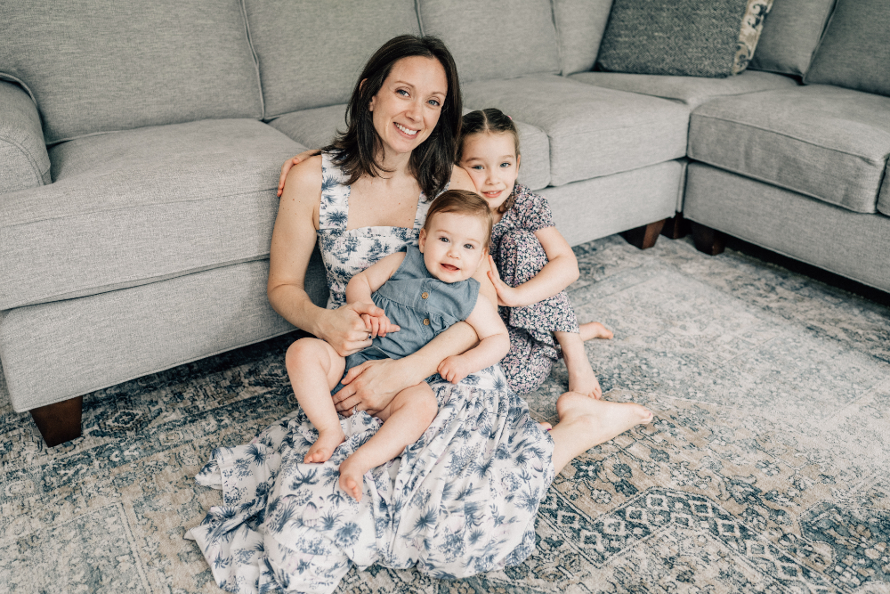 Preserving family memories as a mother sits on the floor and cuddles her two children.